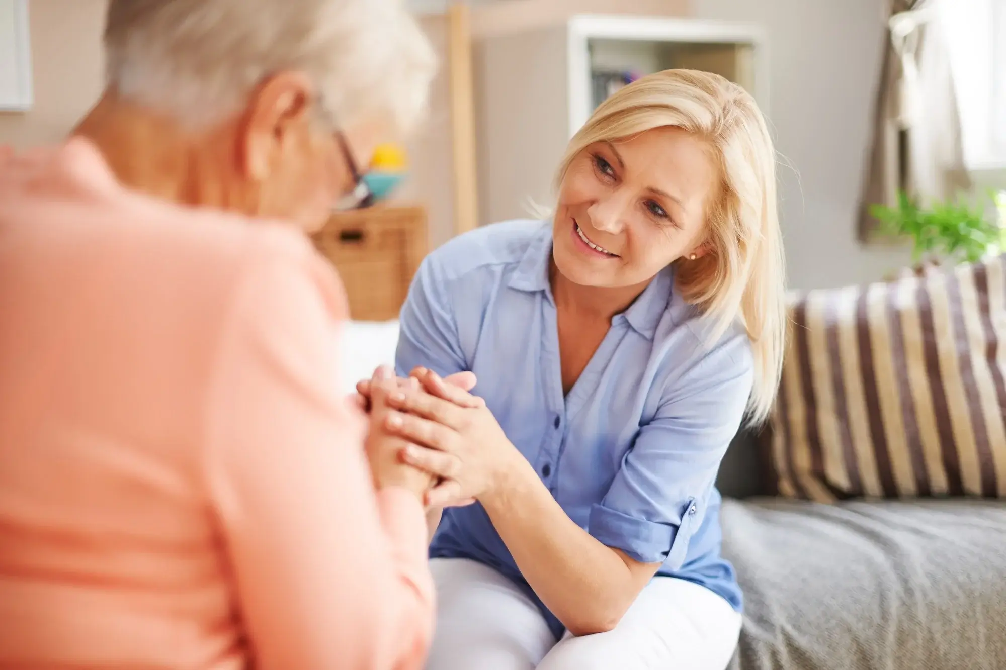Compassionate support is key to Medication Assisted Treatment in Missouri, as shown by a smiling therapist holding a client's hands.
