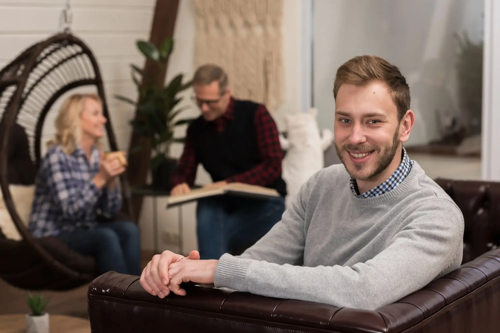A smiling man sits in a relaxed setting, representing the flexible Intensive Outpatient (IOP) addiction treatment available near Sedalia, MO.