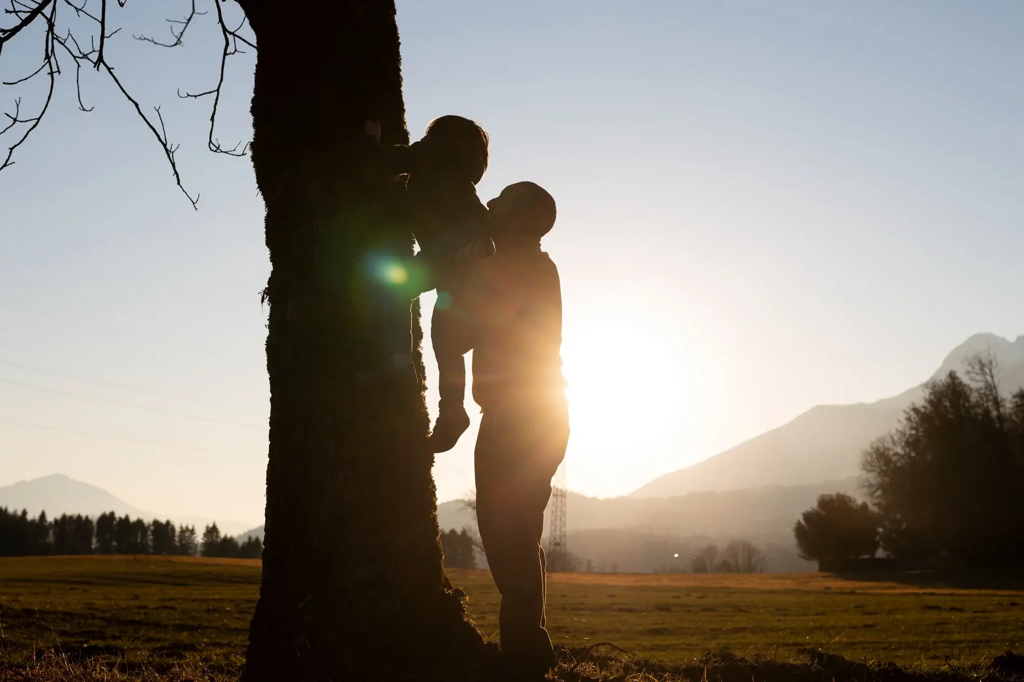 A silhouette of a father lifting his child at sunset symbolizes the restored relationships made possible by opioid addiction treatment in Missouri.