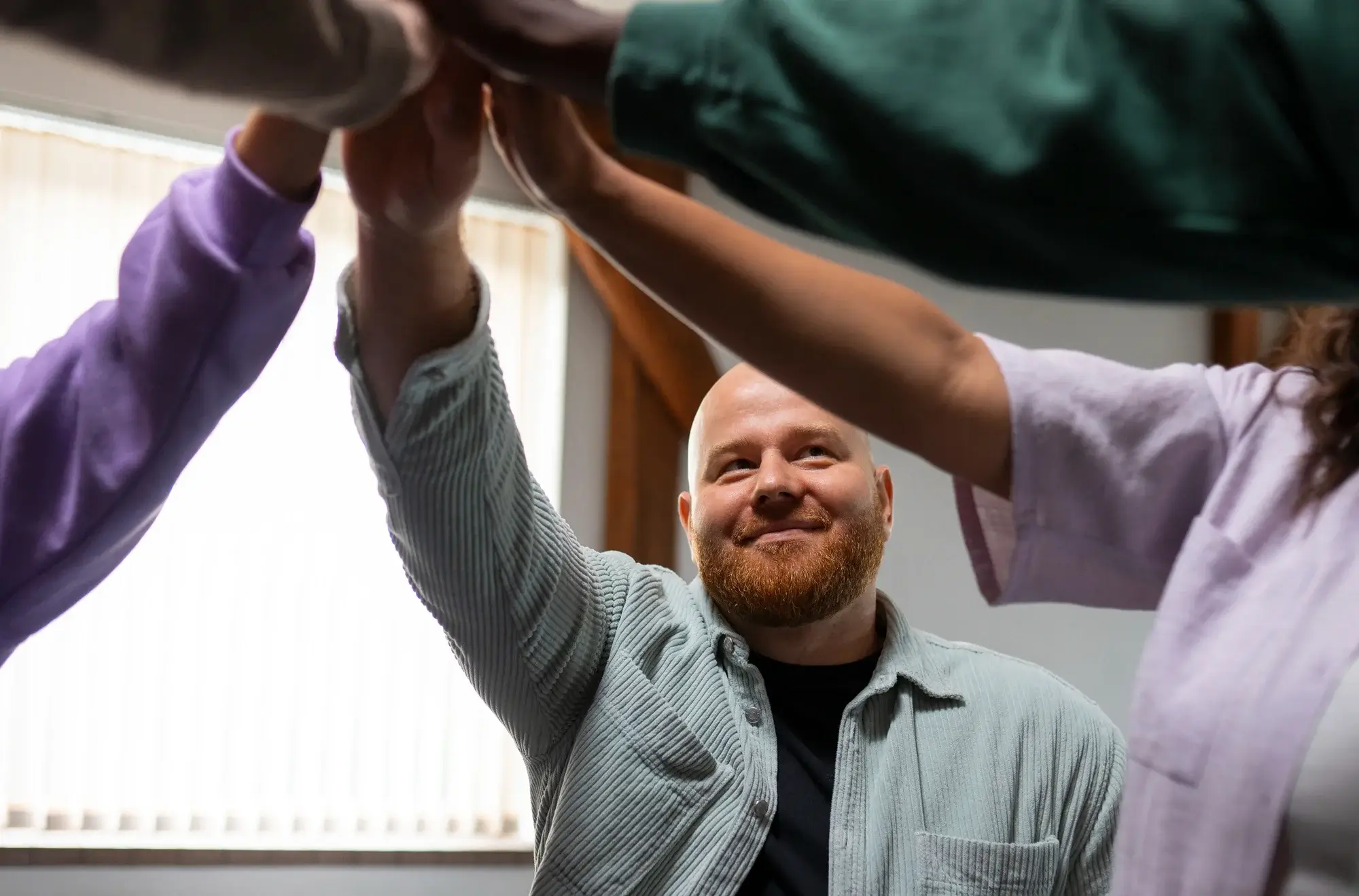 A smiling man receives a supportive high-five to represent the hope found in alcohol rehab in Missouri.