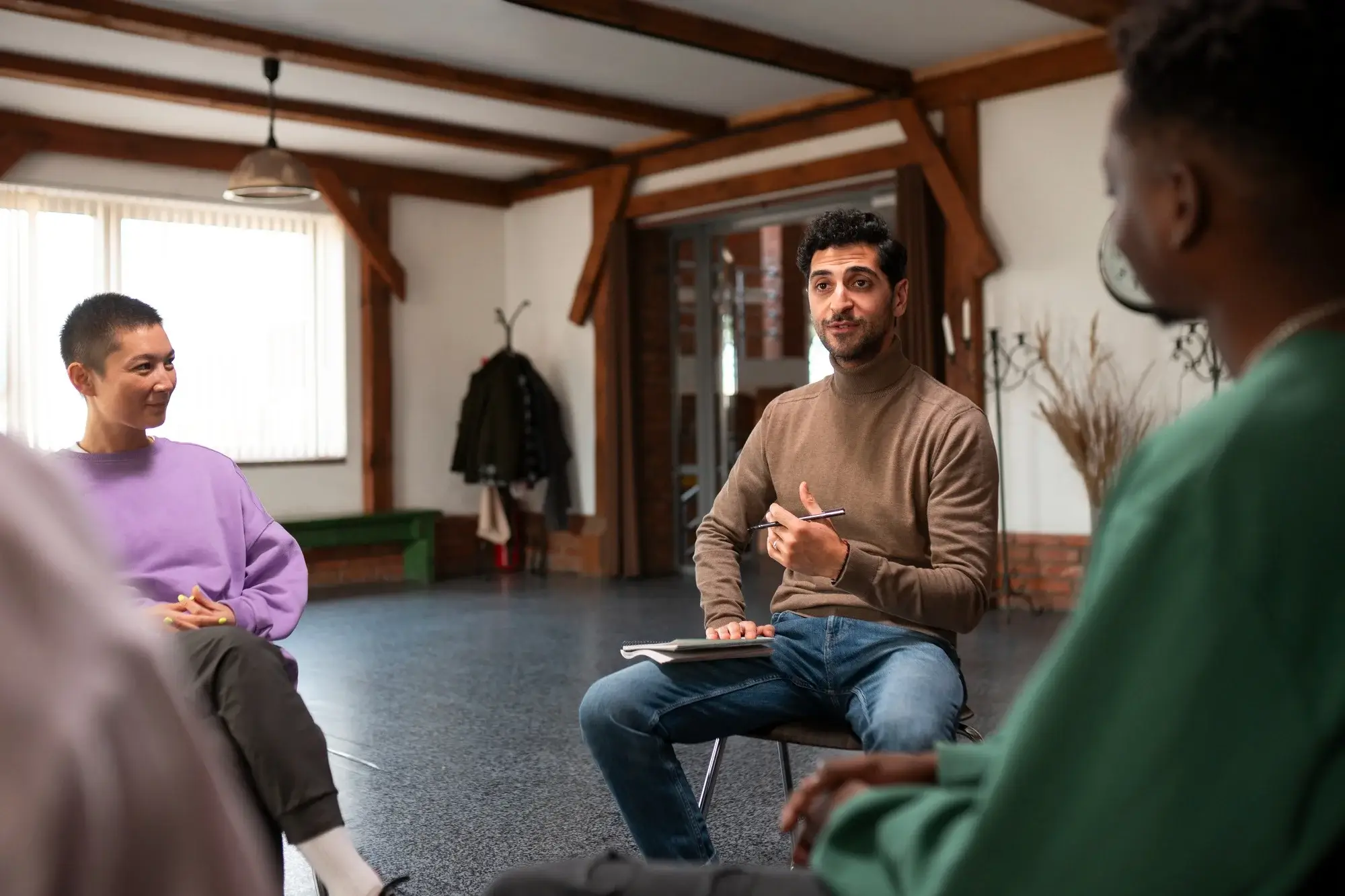 After the rehab admissions process, a man engages in group therapy, sharing his story with supportive peers in a safe environment.