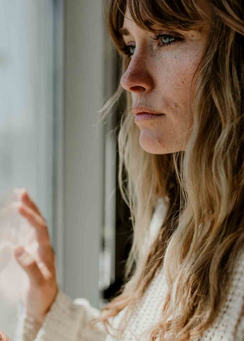 Woman looking out window showing emotional distress during Adderall withdrawal