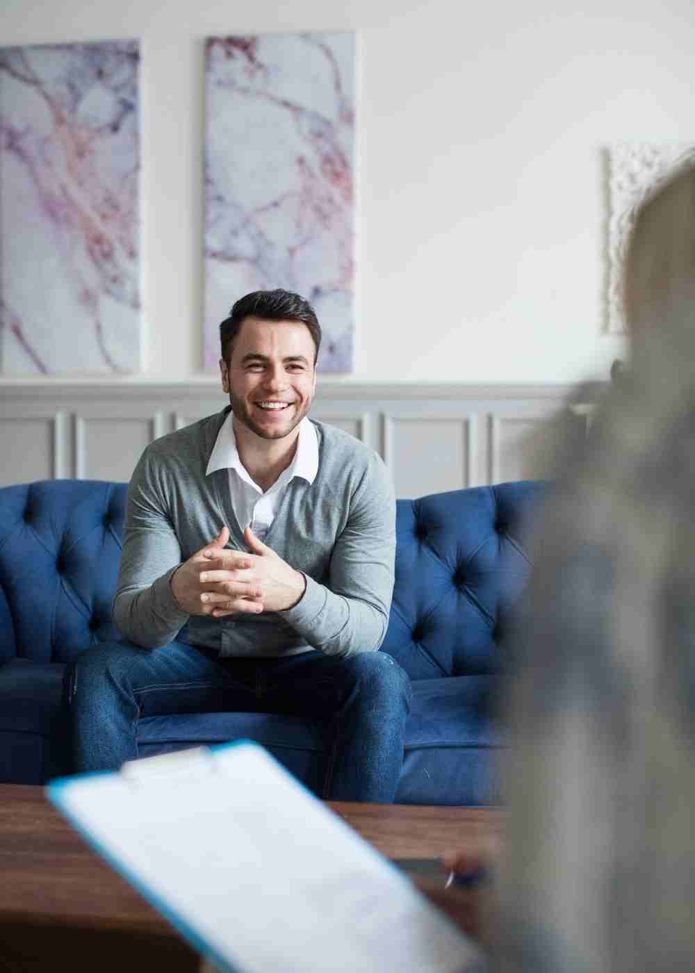 Man smiling during a therapy session for addiction recovery and mental health support