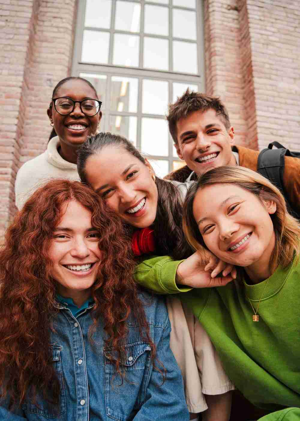 Diverse group of young adults smiling together and building supportive social connections